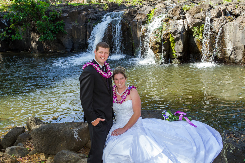 couple sitting beside a waterfall