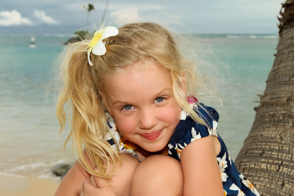 sweet little girl sitting by the ocean