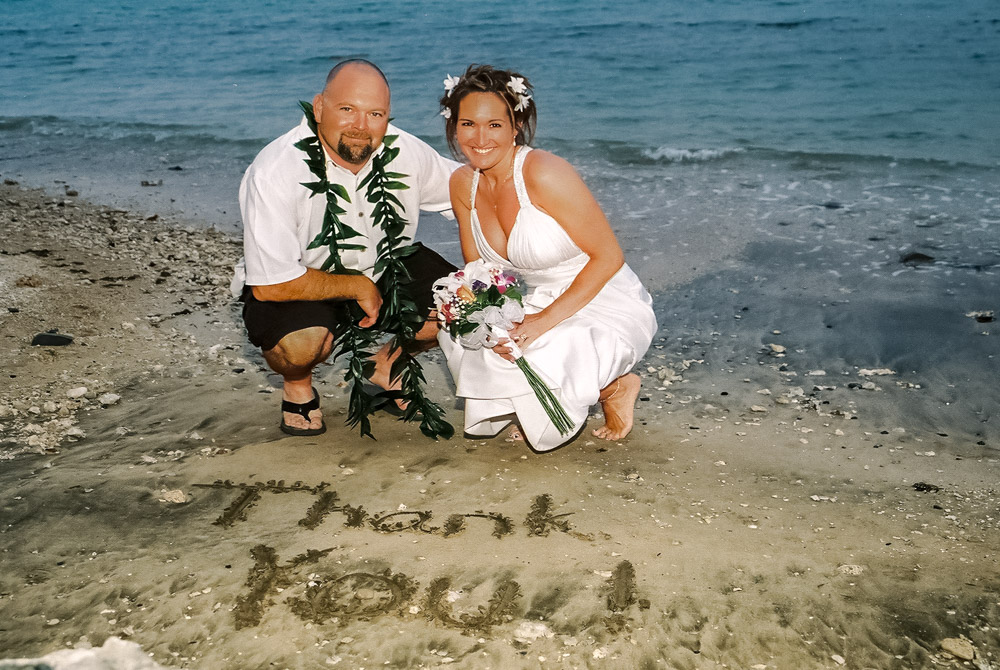 Couple with thank you written in sand