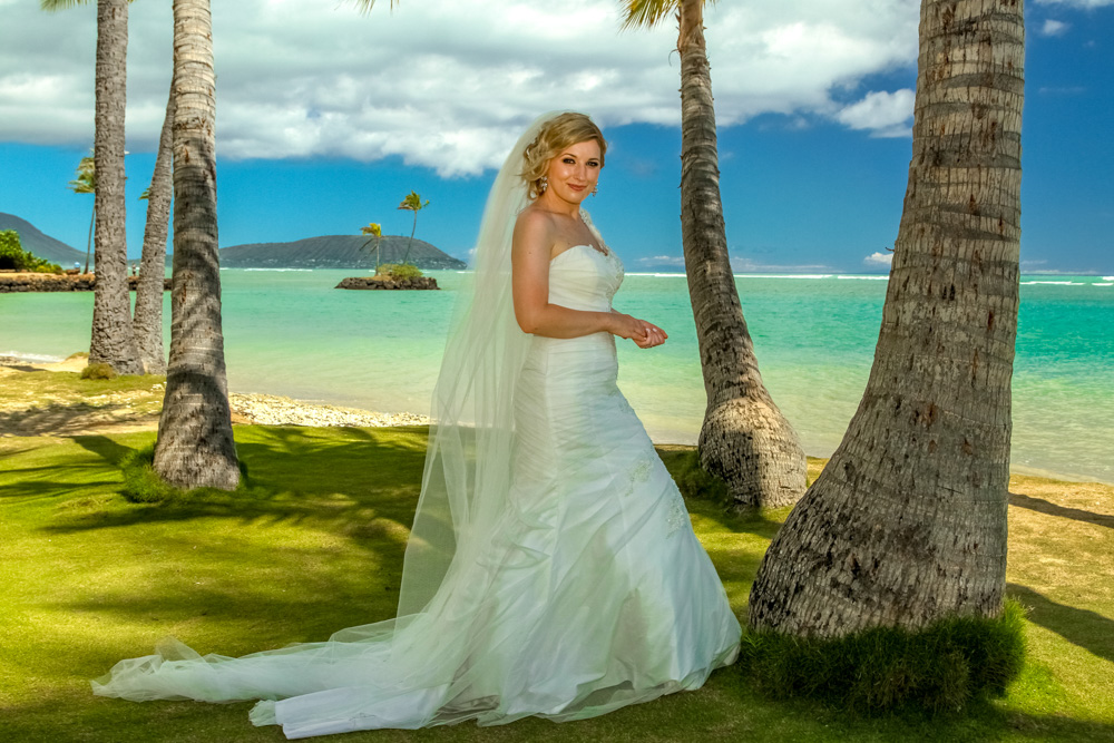 Beautiful bride standing among the palm trees