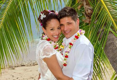 Smiling couple surrounded by palm fronds