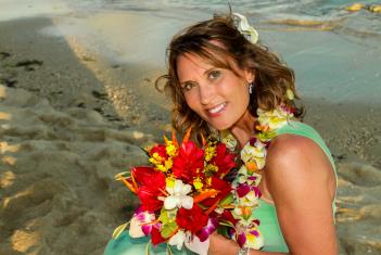 Bride in green with colorful bouquet and lei